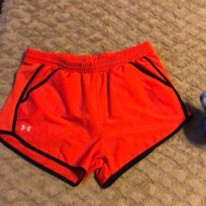 Under Armour athletic running shorts. Redish orange color.